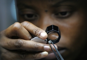 A diamond cutter checks the 2 carat diam
